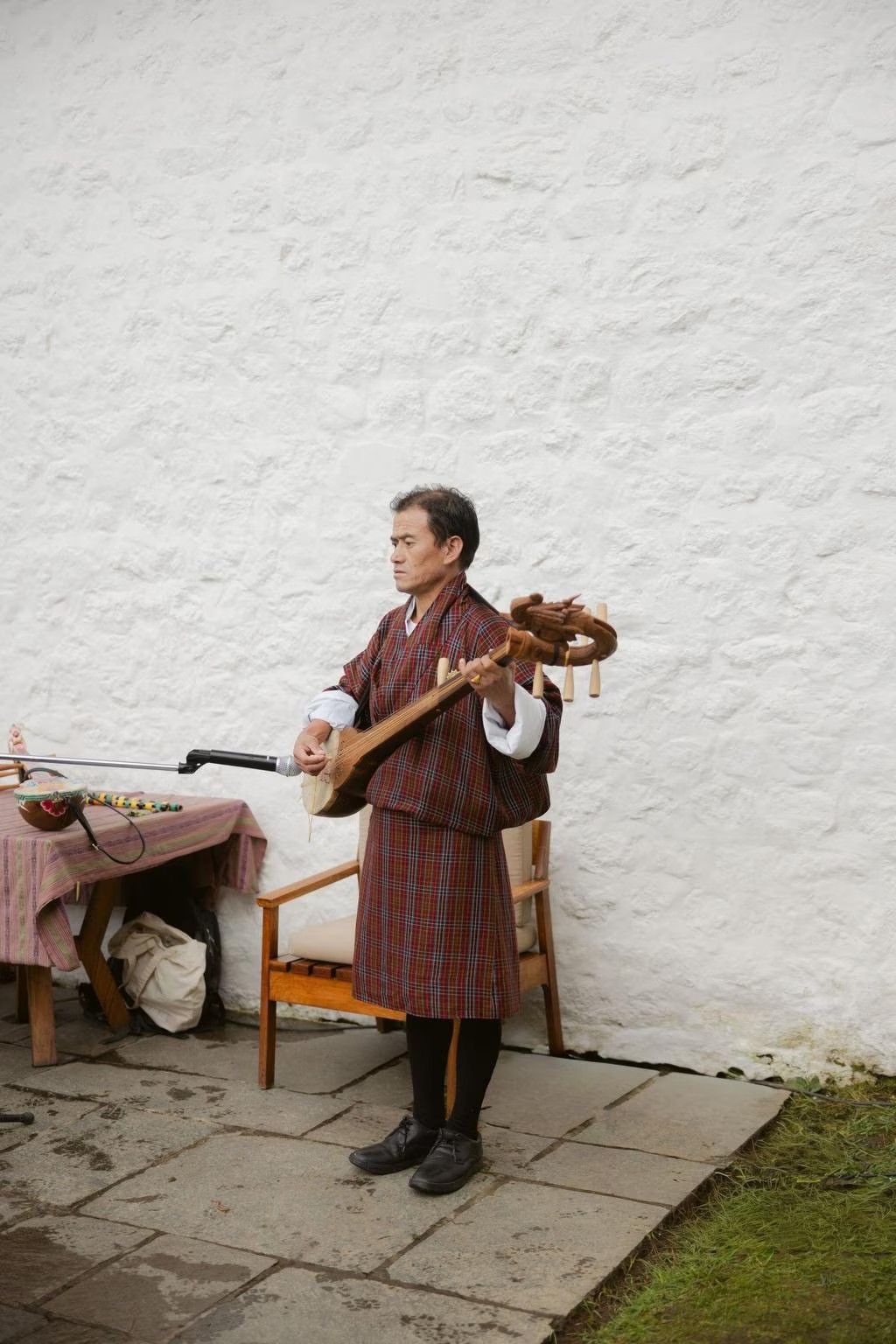 a musician plays the dramyen bhutanese string instrument