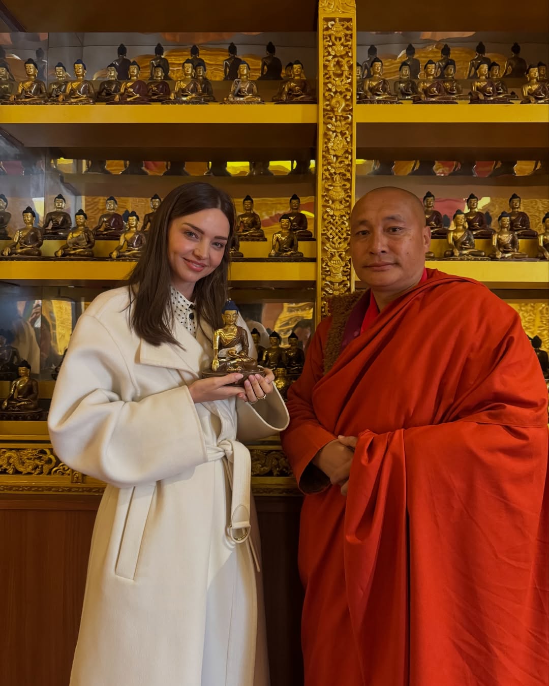 miranda kerr in bhutan with buddha statue and monk and tokyo disneyland 2