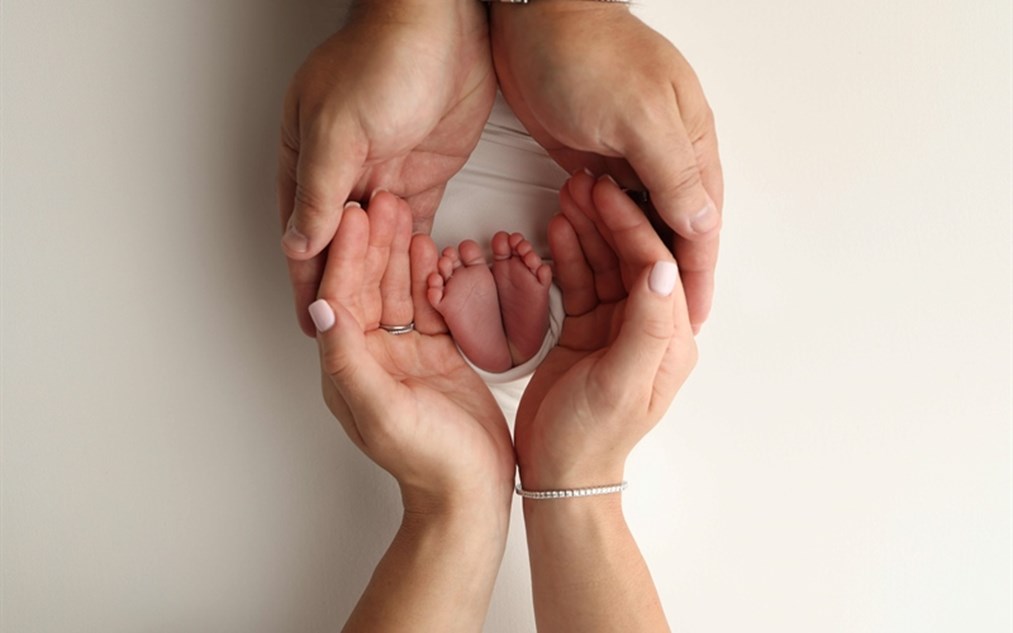 tiny infant feet and adult hands