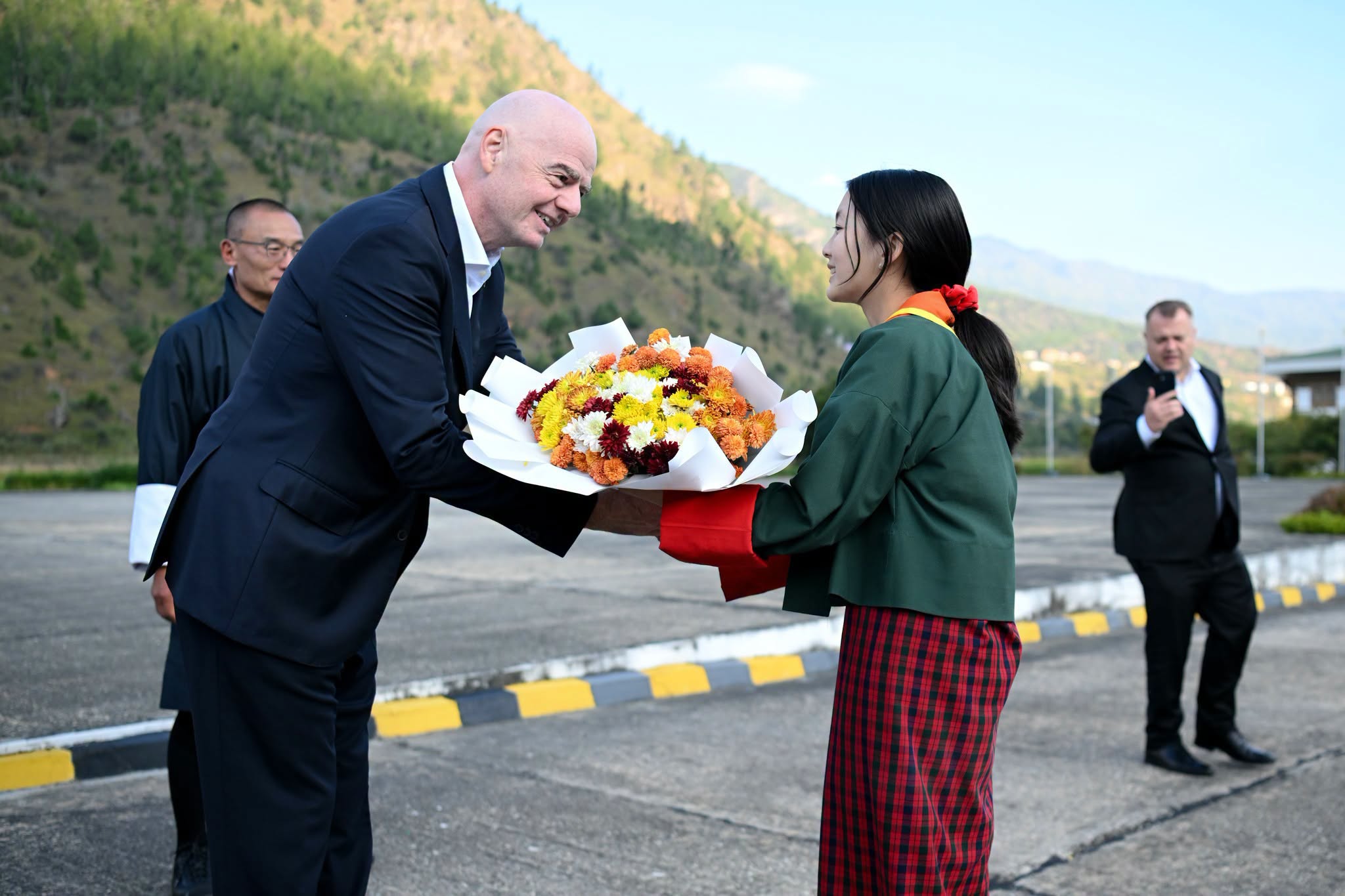 bhutanese student giving flower to fifa president gianni infantino