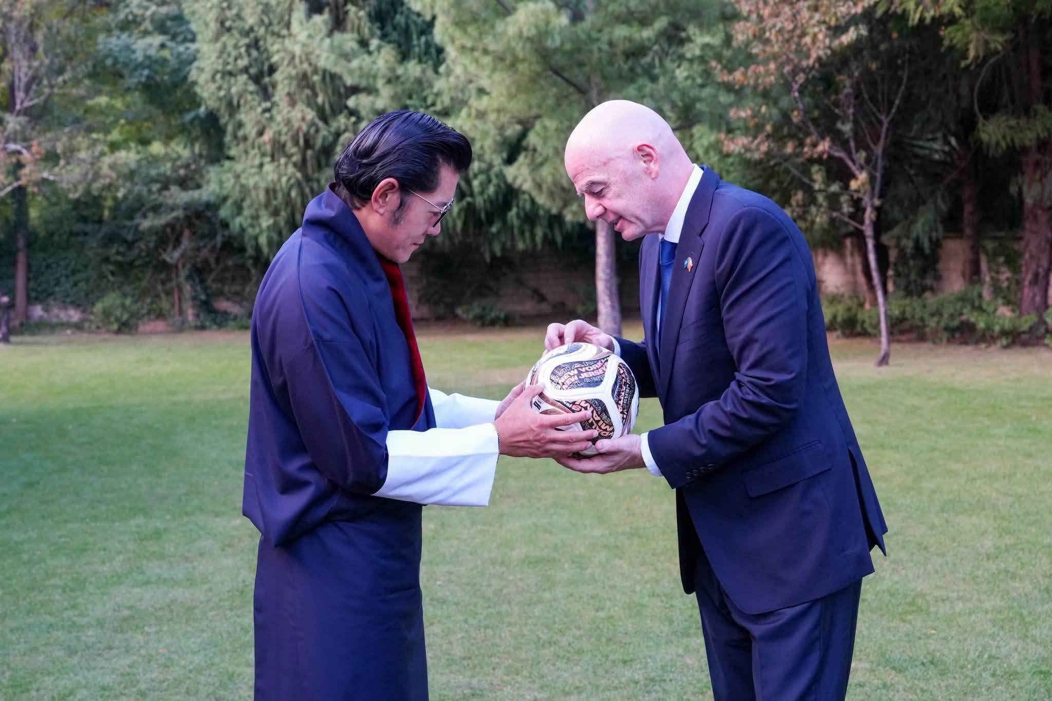 king of bhutan receiving ball from fifa president gianni infantino