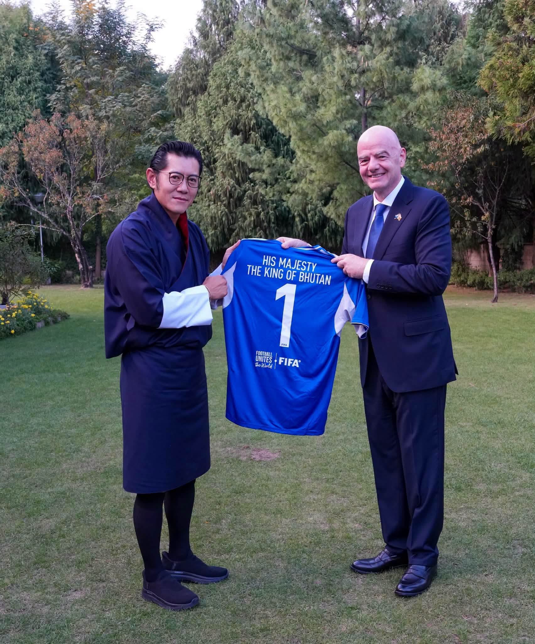 king of bhutan receiving jersey from fifa president gianni infantino